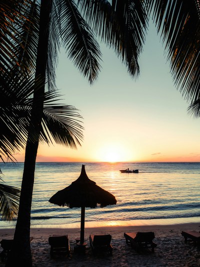 Loungers and umbrellas on teh coast of Maurtitius during sunset